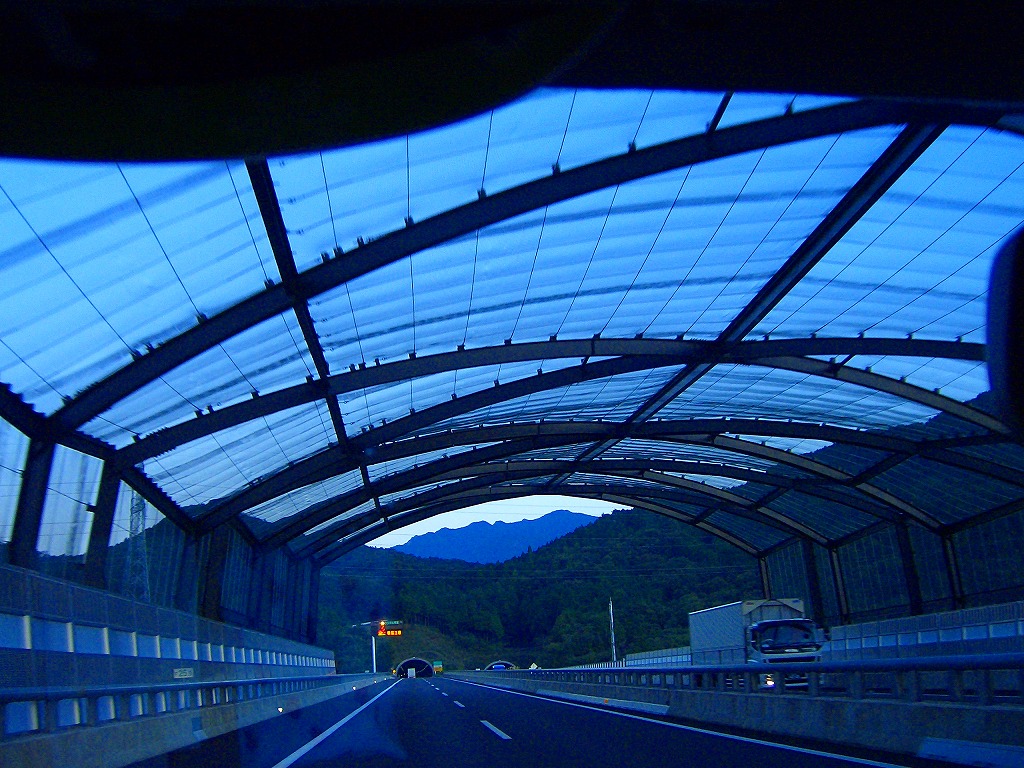 高速道路の上に防球ネットがあり先に安坂山トンネル入り口が見える