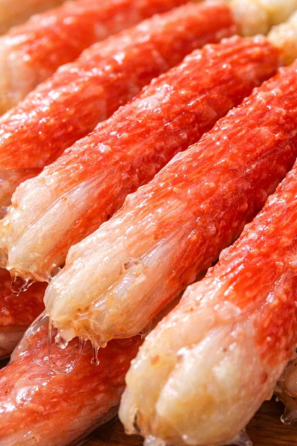 殻を剥いた生の特大ズワイガニの脚の、超クローズアップ写真。繊維が一本一本はっきりと見え、ツヤツヤと輝いていて、今にも溢れ出しそうなジューシーな質感。 